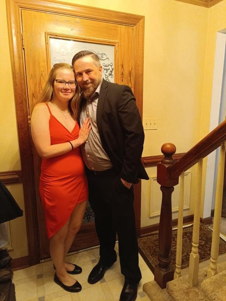 Nick and Libby dressed formally indoors near a staircase