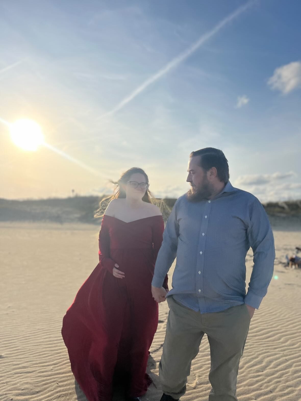 Nick and Libby holding hands on a beach at sunset